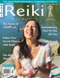 Reiki News Magazine Summer 2018 featuring a woman holding a crystal by a lake.