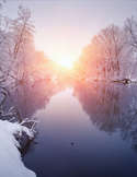 A peaceful winter sunrise reflecting over a calm river surrounded by snow-covered trees.