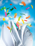 Colorful slips of paper flying into the air above an open, fluttering white desk calendar.