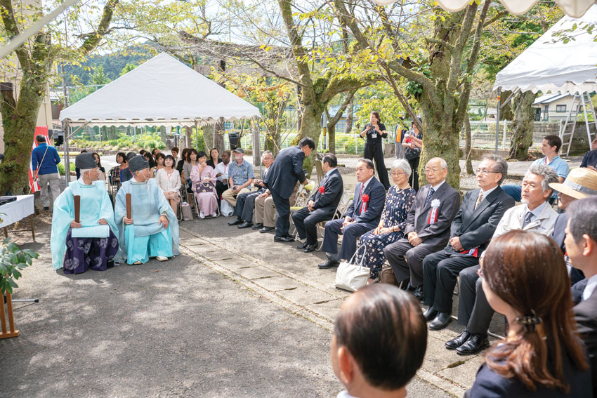Officials are sitting in front of the monument waiting for the ceremony to start.