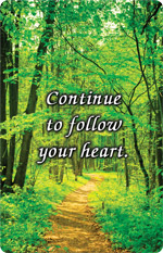 Sunlit forest path surrounded by green trees with the message “Continue to follow your heart.”