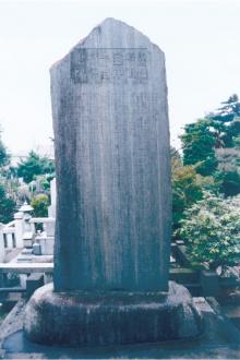 Usui Memorial Stone base in an outdoor cemetery surrounded by greenery.